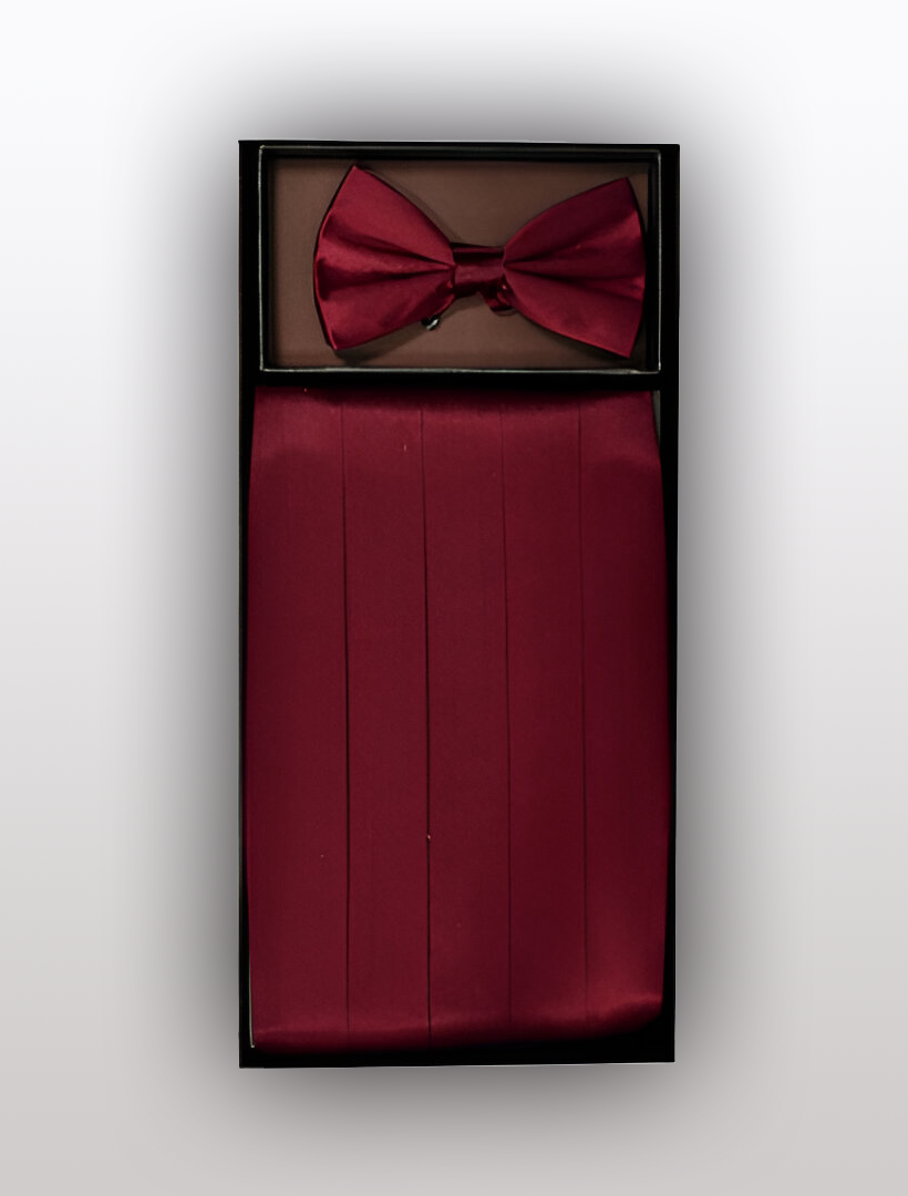 The Men's Silk Wine Cummerbund with Bow Tie by Vesuvio Napoli is elegantly presented in a black display box against a pristine white background. Crafted from 100% silk, this maroon set is perfect for adding a touch of sophistication to any tuxedo ensemble.