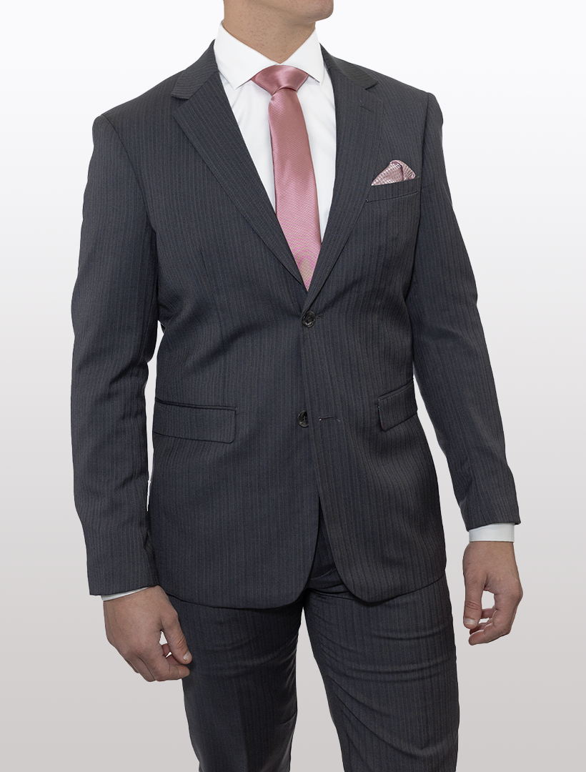 The individual is dressed in a Douglas Grahame Men's Grey Chalk Stripe Wool Slim Fit Suit, complemented by a white shirt and a pink satin tie. To complete the look, they are accessorized with a matching pink pocket square, making it an ideal choice for an elegant men's wedding suit or a stylish prom suit for men.