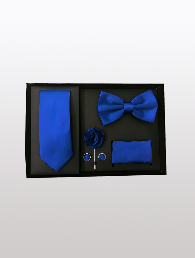 Introducing the Men's Five Piece Solid Royal Blue Gift Box by Vesuvio Napoli: an ideal choice for formal events. This elegant set includes a slim fit tie, bow tie, pocket square, lapel flower, tie bar, and cufflinks—all beautifully presented on a sleek black board.