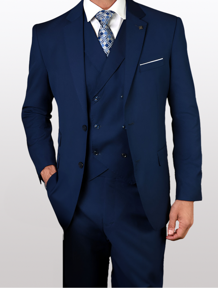 Against a simple backdrop, an individual confidently sports the Statement Mens Sapphire Blue Modern Fit 100% Wool Vested Suit by the brand Statement, enhanced by a stylish patterned tie. With one hand casually placed in their pocket, they exude an aura of elegance and sophistication.