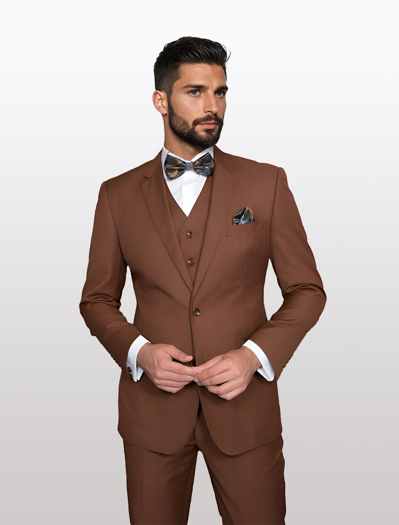 A man wears a Statement Men's Solid Copper Modern Fit 100% Wool Vested Suit with a patterned bow tie and white shirt, standing against a plain background.