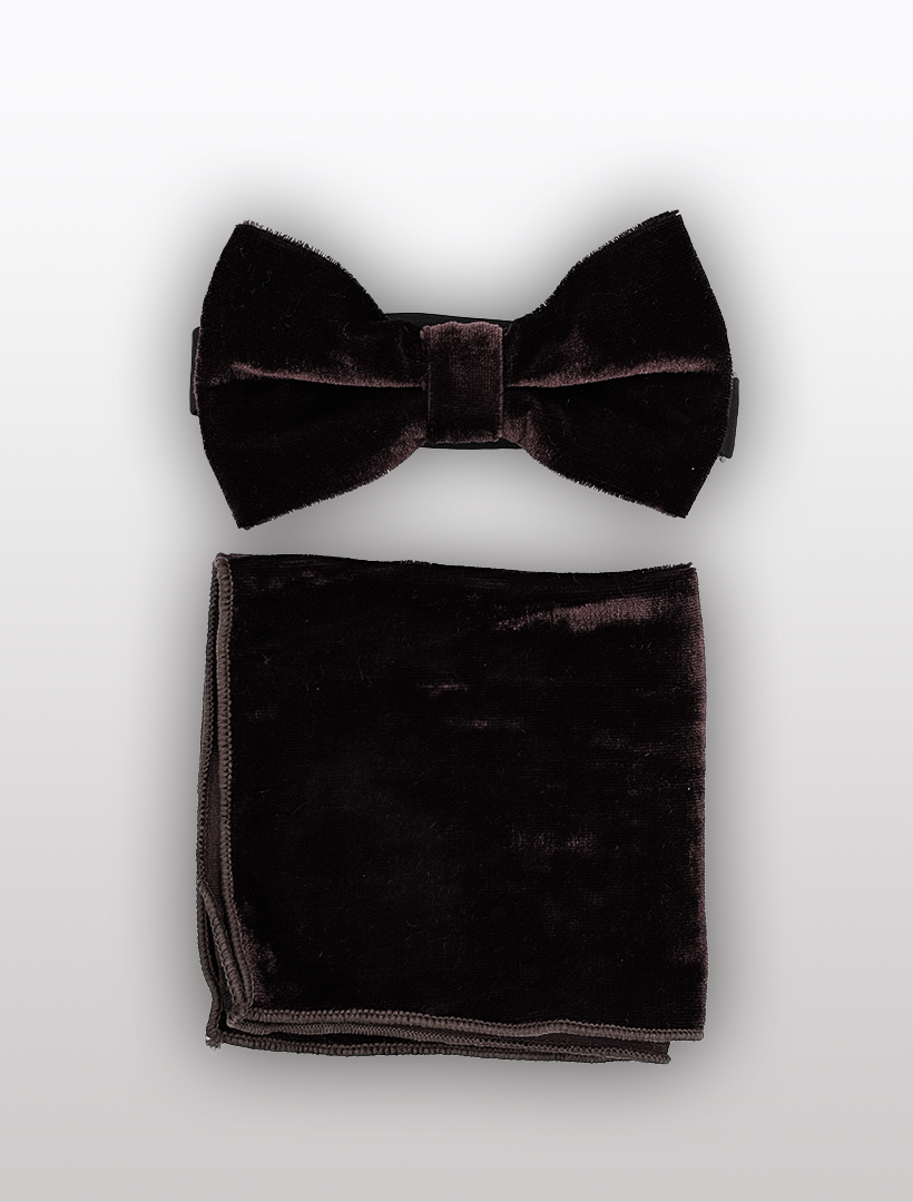 A brown velvet bowtie with adjustable fit, accompanied by a matching pocket square set on a plain background, from the brand Ckl.