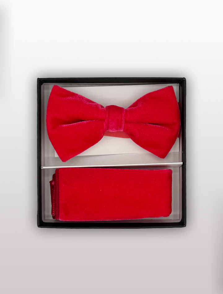 A luxurious red velvet bow tie and matching handkerchief from Ckl, featuring an adjustable fit, gleam in their black display box on a pristine white background.