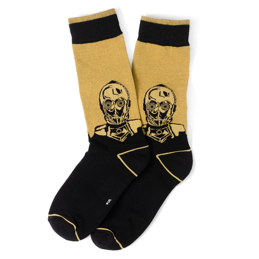A pair of black and gold Star Wars Yoda, R2-D2, and C-3PO Dress Socks 3-Pack with Rebel Crest Lapel Pin Gift Set crew socks featuring a graphic of C-3PO.