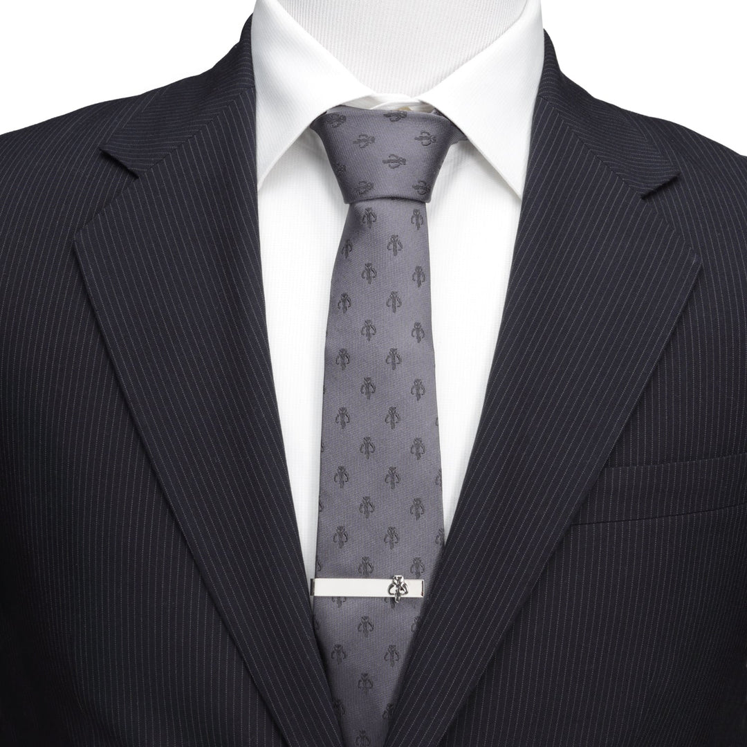 Star Wars Mandalorian Mythosaur Gray Silk Tie in gray with a repeating Mythosaur skull pattern, worn with a white shirt and black pinstripe suit, secured by a silver tie bar.