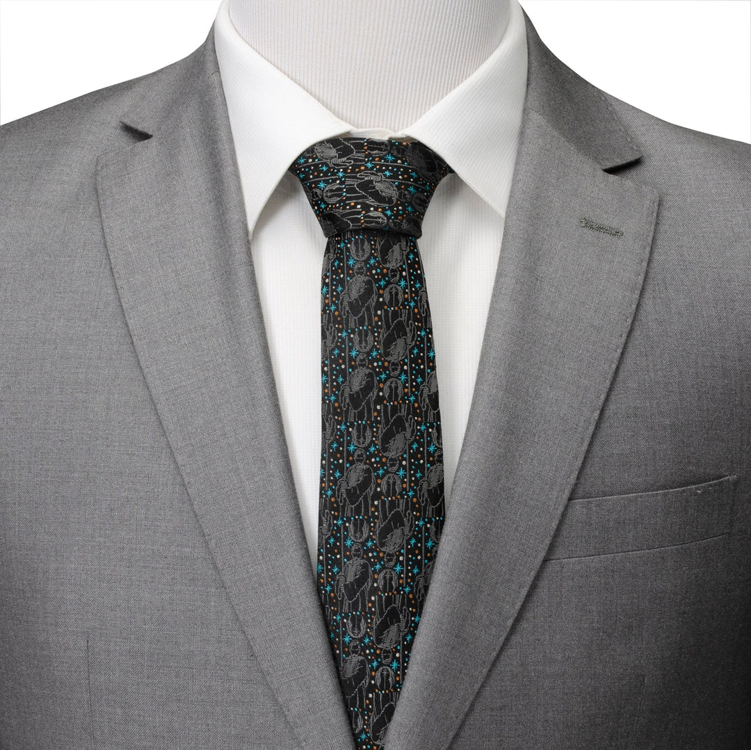 A black Star Wars Obi-Wan Kenobi Gray Tie with a repeating pattern of Obi-Wan Kenobi and desert cactus icons, worn with a white dress shirt and a gray suit jacket.