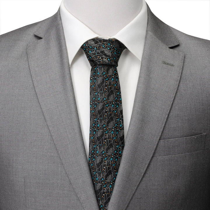 A black Star Wars Obi-Wan Kenobi Gray Tie with a repeating pattern of Obi-Wan Kenobi and desert cactus icons, worn with a white dress shirt and a gray suit jacket.