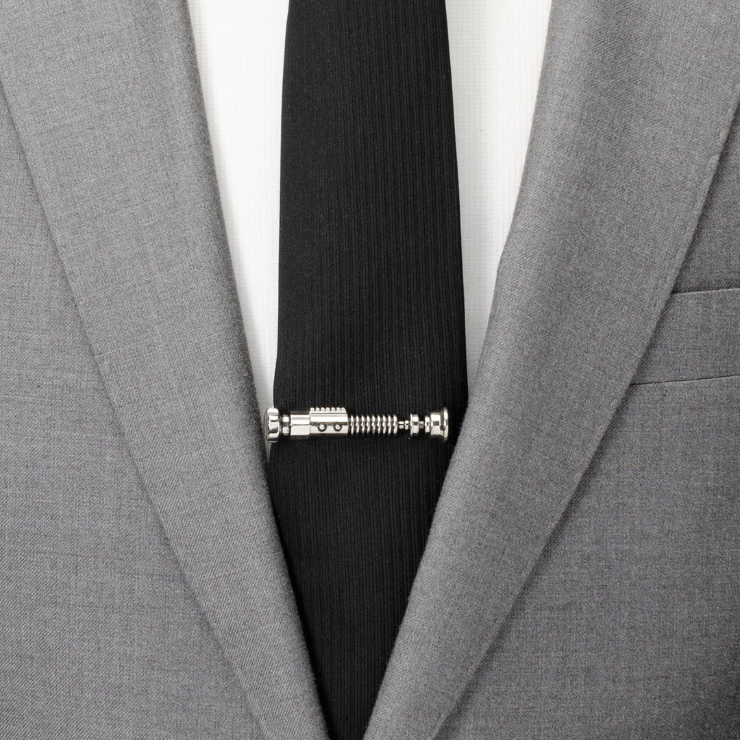 Silver-tone Star Wars Obi-Wan Kenobi Tie Clip on a black necktie worn with a grey suit jacket.