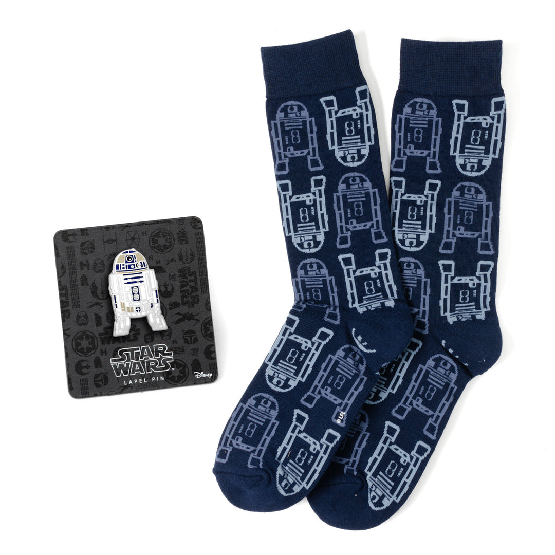 A pair of navy R2-D2 Star Wars R2-D2 Light and Dark Blue Dress Socks and Lapel Pin Gift Set with a repeating droid pattern and matching lapel pin on a display card.