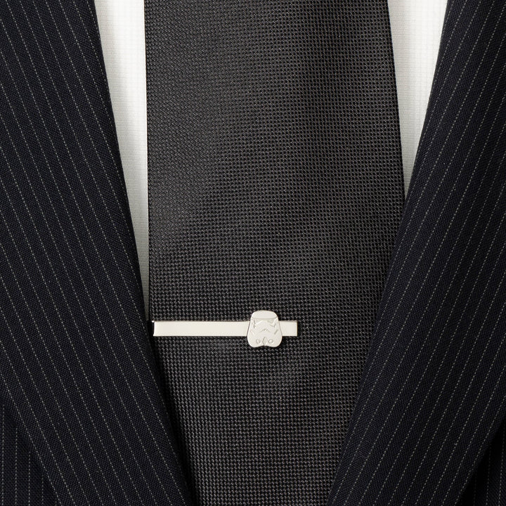 A Star Wars Stormtrooper Stainless Steel Tie Bar clipped onto a black necktie worn with a pinstripe suit jacket.