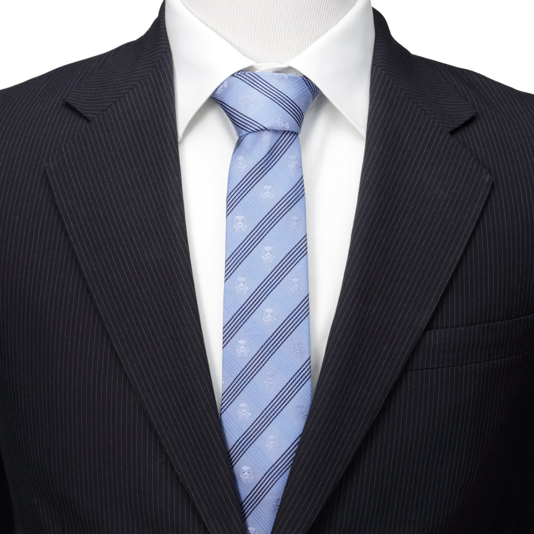 Star Wars Stormtrooper Blue Plaid Tie in light blue with dark blue diagonal stripes and small Stormtrooper helmet icons, worn with a white dress shirt and dark pinstriped suit jacket.