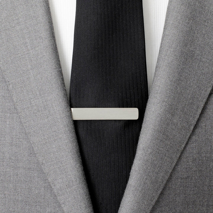 A Star Wars Princess Leia and Han Solo “I Love You / I Know” Hidden Message Tie Bar worn on a black tie over a white shirt and gray suit jacket.