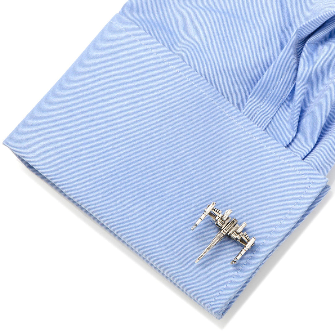 Silver-toned Star Wars X-Wing 3D Cufflinks attached to a light blue dress shirt cuff.