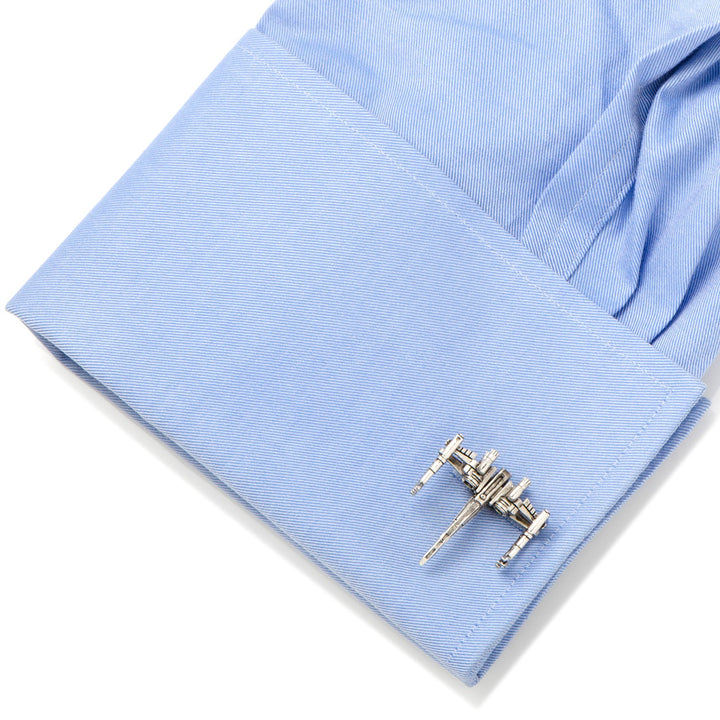 Silver-toned Star Wars X-Wing 3D Cufflinks attached to a light blue dress shirt cuff.