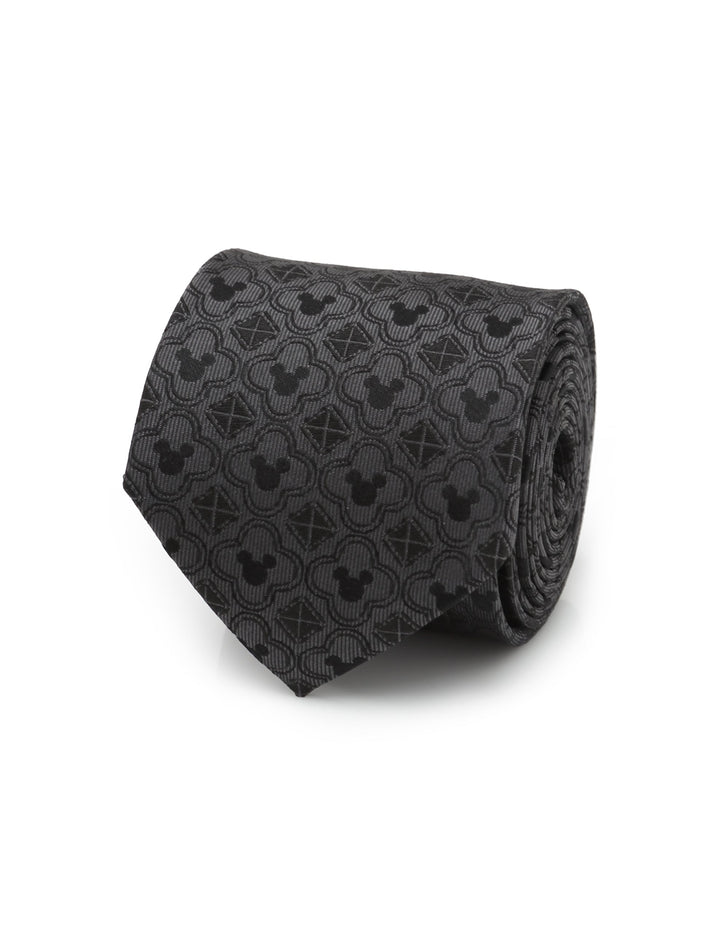 Disney Mickey Mouse Pattern Black Men’s Tie by Cufflinks.com, shown as a black silk necktie rolled into a coil with a repeating pattern of Mickey Mouse silhouettes and geometric shapes.