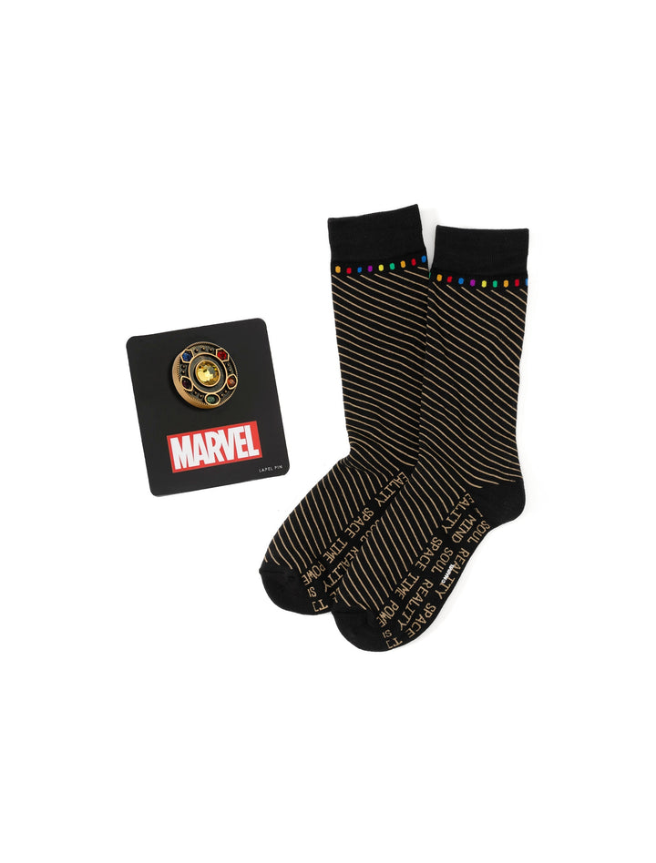 A Marvel Avengers Infinity Stone Stripe Black Gift Set featuring a gold-tone Infinity Gauntlet lapel pin on a display card and black socks with diagonal stripes.