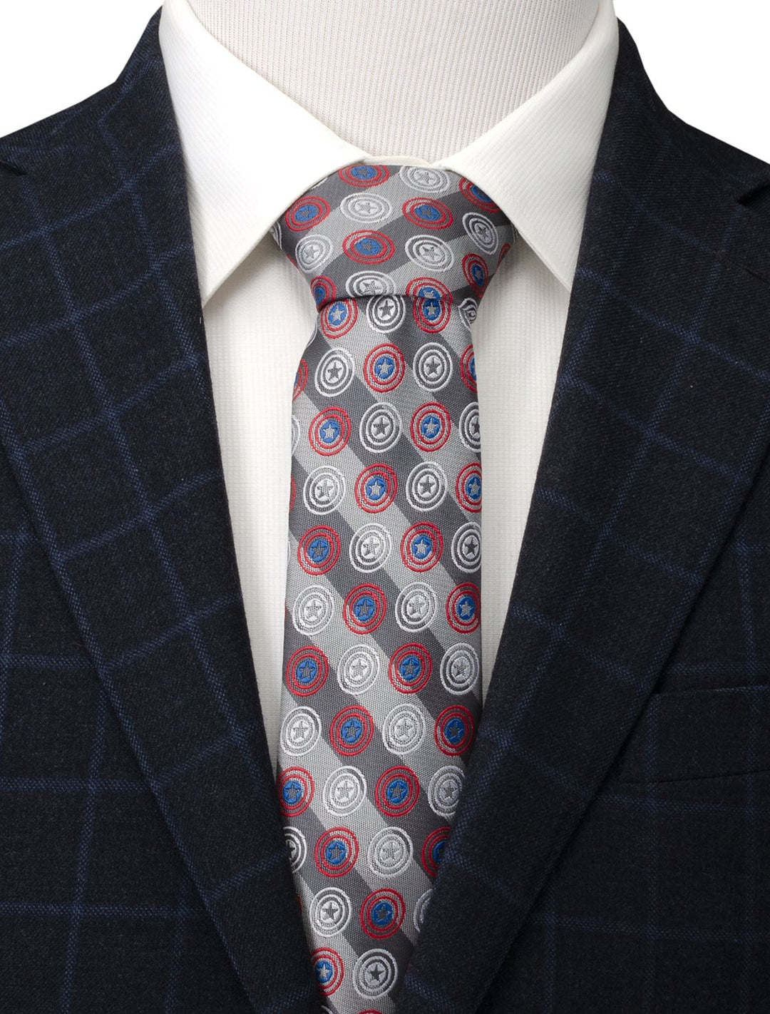 A Marvel Captain America Gray Stripe Men’s Tie with a repeating pattern of red, white, and blue shield emblems, worn with a white shirt and navy blazer.