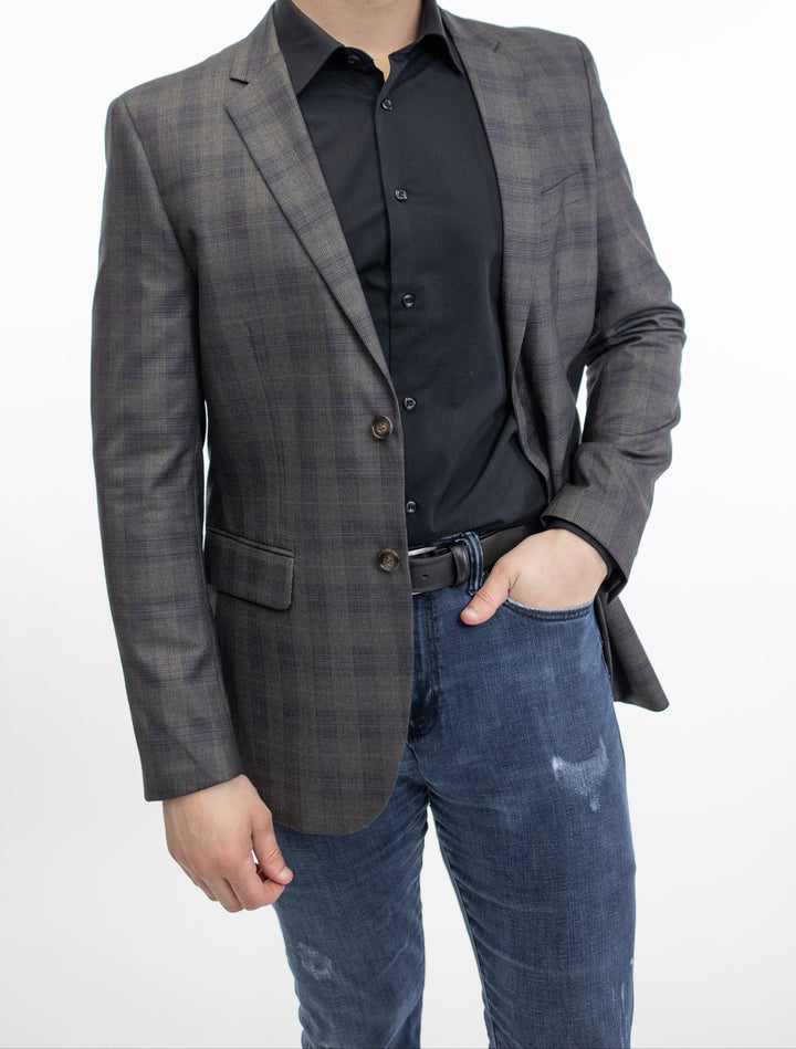 A man in jeans and a FUBU Slim Fit Brown Glen Check Sport Jacket from Fubu The Colle, is posing for a photo.