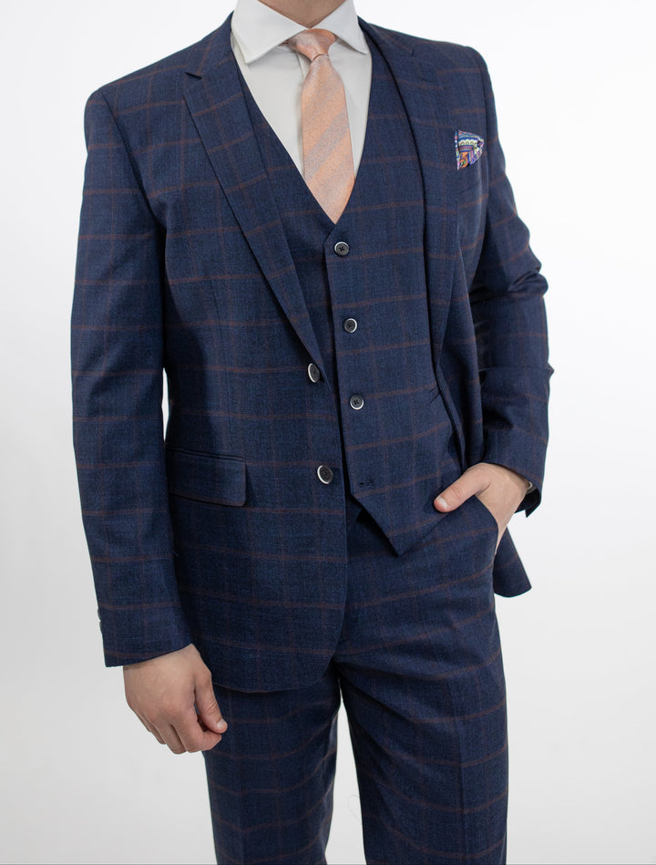 A man is posing in a FUBU Dark Blue and Burgundy Windowpane Vested Suit by Fubu The Colle.