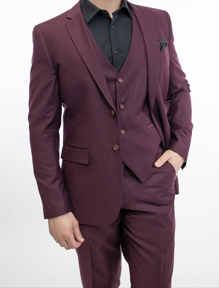 A man is posing in a FUBU Burgundy Vested Suit designed by Fubu The Colle.