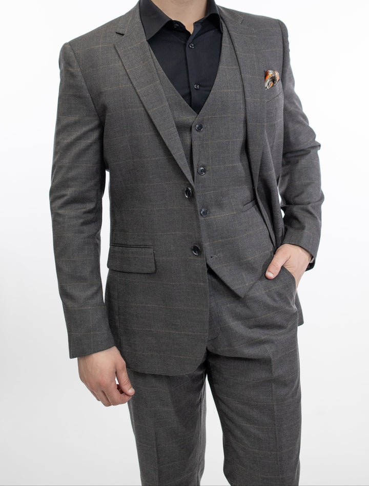 A man in a FUBU Charcoal Grey Windowpane Vested Suit by Fubu The Colle posing for a photo.